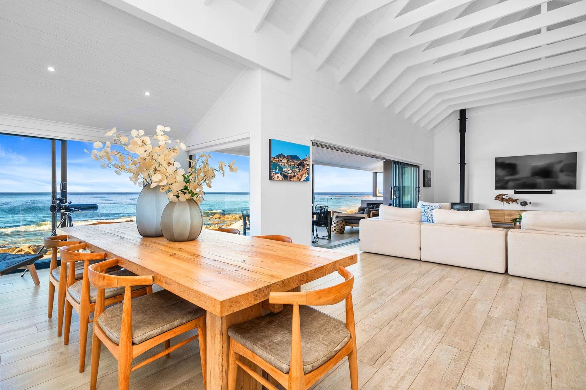 An indoor-outdoor lounge with a fireplace, opening onto a deck facing the Atlantic