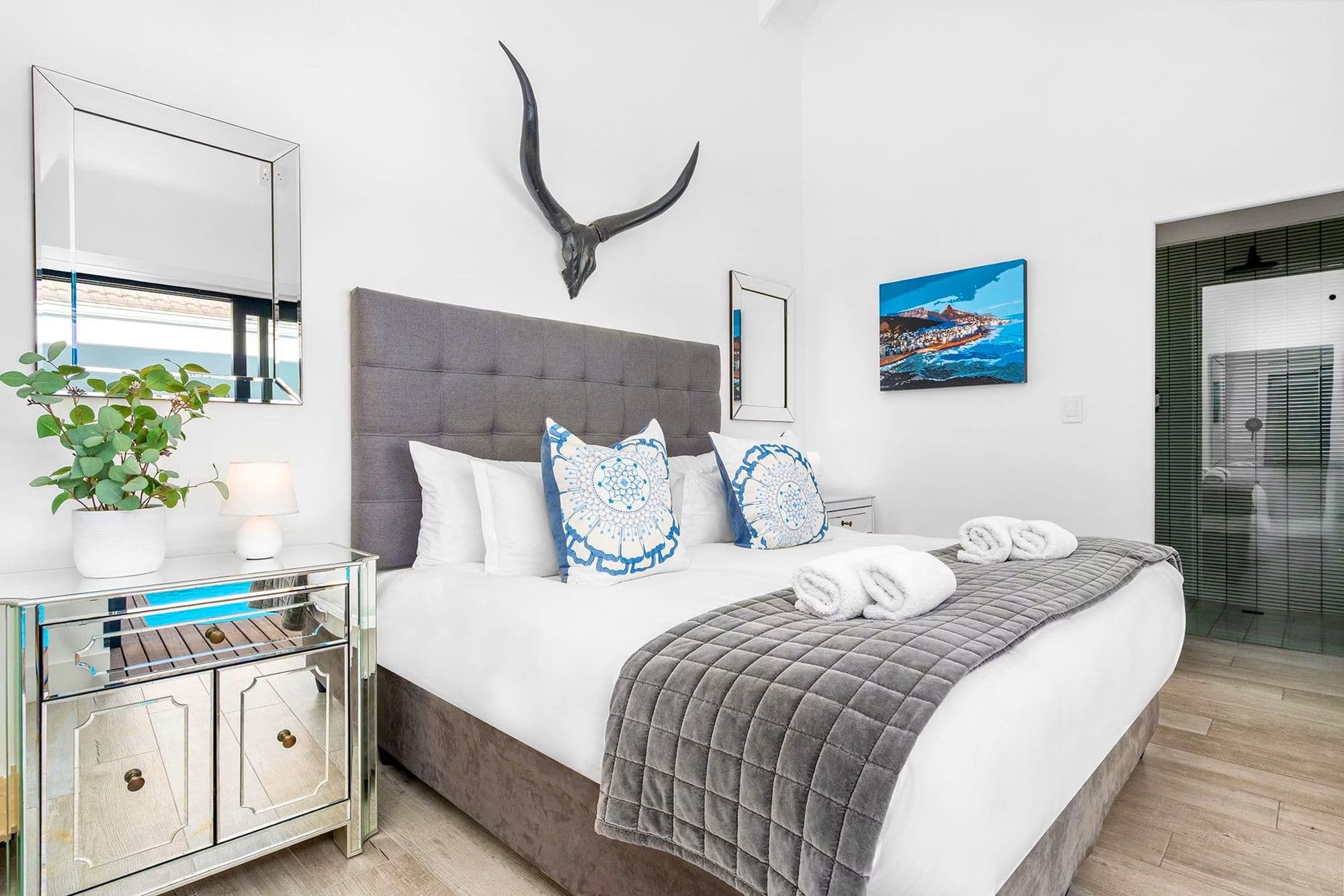 A bedroom dressed with mounted horn art and mirrored furniture